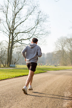 Man running on a asphalt path in the Amsterdamse Bos.