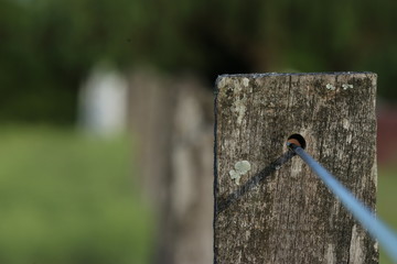 alambre pasando por hueco en poste de madera