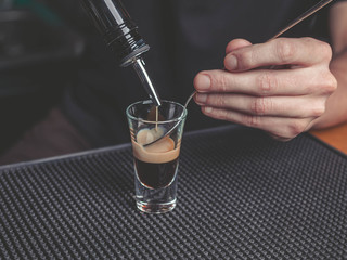 The bartender prepares a B-52 cocktail at the bar