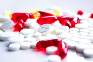 Background of assorted pharmaceutical capsules and medication in different colors, selective focus