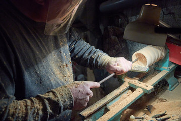 A man in the Studio hones wood blanks on a woodworking machine. turning wood on a lathe