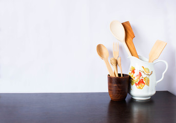 Fototapeta na wymiar Kitchen utensils and dishware on dark table over white background. Kitchen interior background