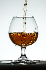 Glass white background vignette dishes with Cognac Alcohol Tea 