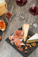 Assorted Italian antipasti on rustic background