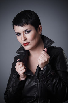 Brunette woman dressed in leather jacket, androgynous appearance, beauty and short hair