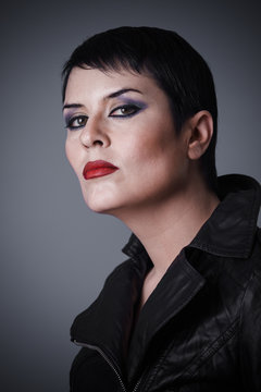 Brunette woman dressed in leather jacket, androgynous appearance, beauty and short hair