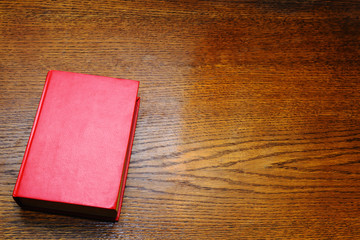 Red book on a wooden background