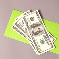 Charity. Green envelope with money on the grey background