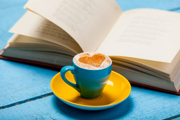 Cup of cappuccino with book