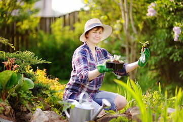 Portrait of smiling beautiful middle age female gardener