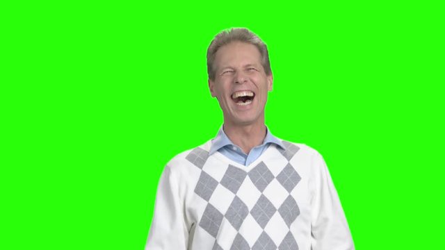 Man laughing on chroma key background. Mature man laughing and gesturing with hands on green screen. Human positive emotions.