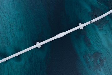 Aerial shot of a bridge over sea strait. Visible depth with blue and green colours near Tromso. Sommaroy, Norway