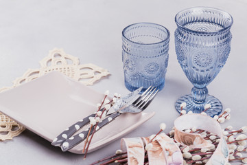  White plate, blue glasses, cutlery and pussy willow