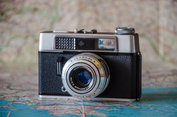 Old camera on the map background.