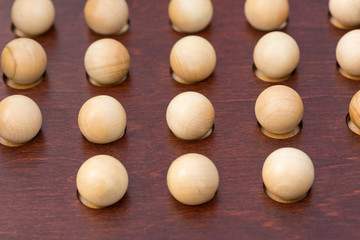 game, amusement, abstract concept. top view of wooden balls of light colour that are easily standing out on the background of dark shade, they are crafted for playing