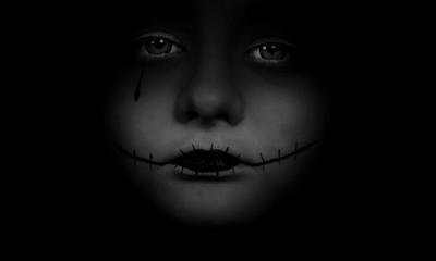 Portrait of teenage girl closeup. Body parts are hidden in black. On the face of the girl makeup.

