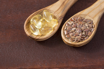 Fototapeta na wymiar Flax seeds and oil in capsules - Linum usitatissimum
