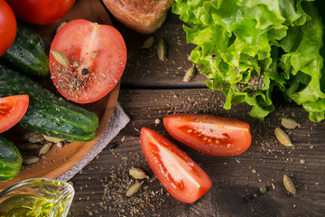 Obraz na płótnie Canvas tomato, cucumber, lettuce, baguette, olive oil and spices