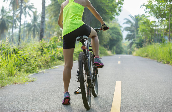 fitness woman cyclist cycling mountain bike on tropical forest trail