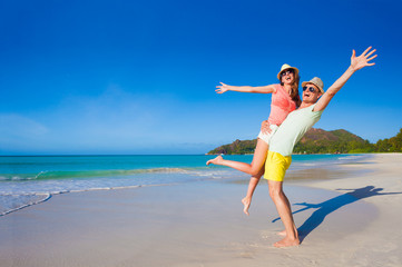 Fototapeta na wymiar young family in love having fun at tropical Cote d Or beach. Praslin, Seychelles