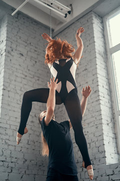 The two young modern ballet dancers in black suits over urban background.
