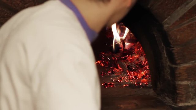 italian pizzaiolo is looking for the right fire quality in wood fired stone oven