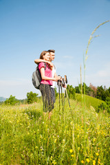 active Beautiful young couple hiking ina nature climbing hill or mountain - man and woman trekking