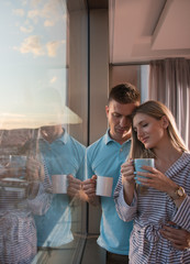 Obraz na płótnie Canvas young couple enjoying evening coffee by the window