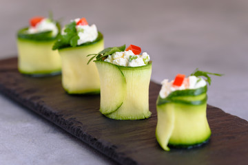 Rolls of zucchini stuffed with cheese and chives and red paprika. 