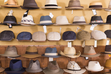 trilby and panama hats hanging on the shelf in the shopping store