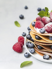 Delicious crepes with fresh blueberry and raspberry.  An healthy meal of Pancakes with berries.