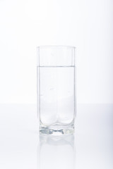 Glass of purified water on white background, reflection