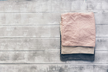 Three linen napkin on wooden background. Pastel tones