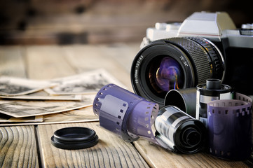 Camera film and vintage prints of aged wooden background.