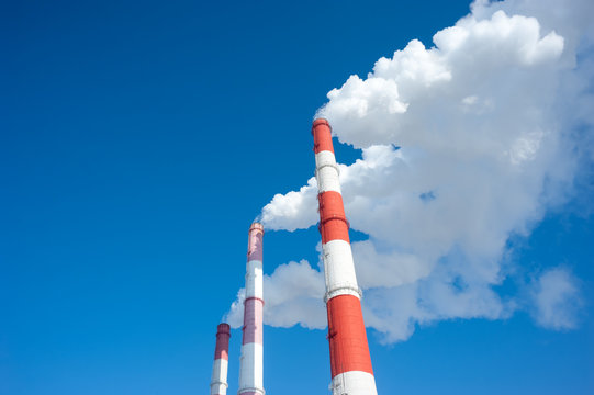 Air pollution by smoke coming from three factory chimneys