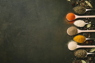 Spices and herbs over black stone background. Top view. Copy space