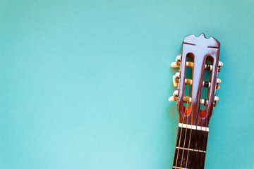 Acoustic classic guitar head on blue background. Simple musical instrument with copy space.