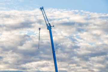 Obraz premium the crane's arm against the cloudy sky at sunset
