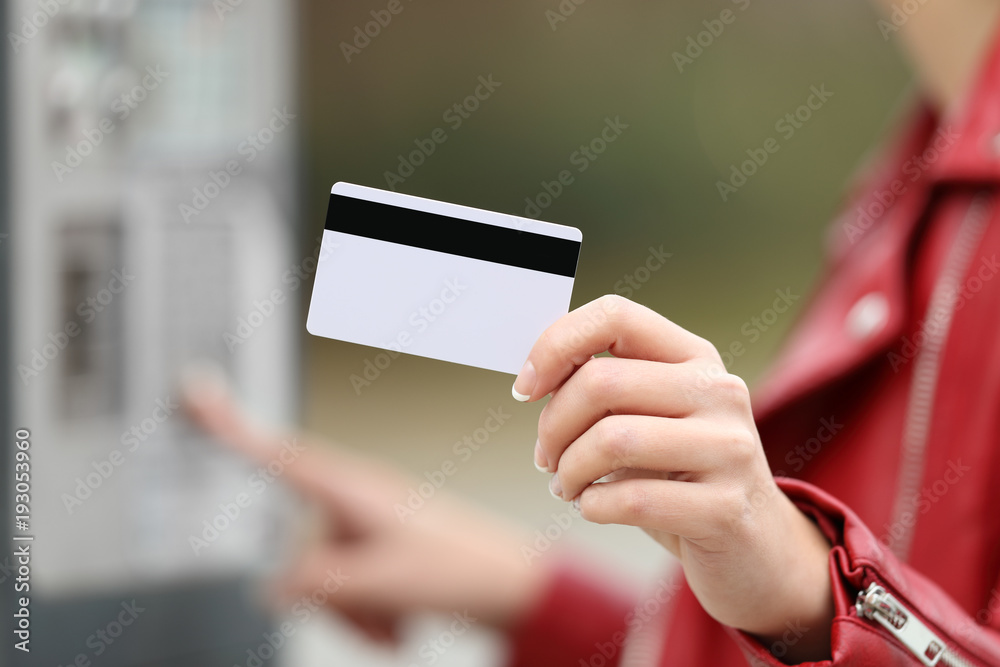 Wall mural woman using a credit card to pay in a payment machine