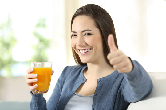 Satisfied consumer holding an orange juice glass