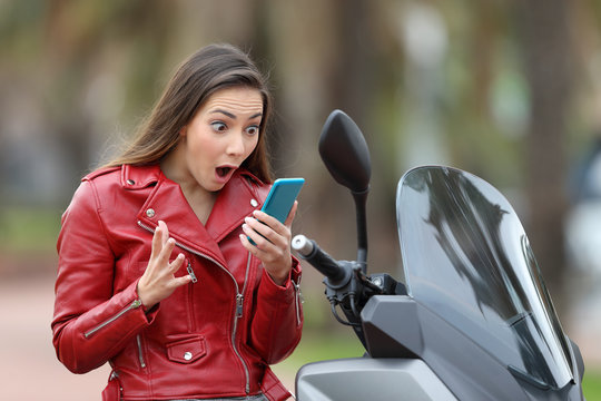 Amazed motorbiker reading exciting news on line