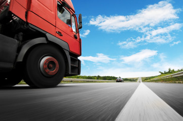 Big truck in motion on the countryside road against sky