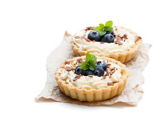 Delicious  tarts with cream and fresh blueberry isolated on white