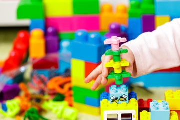 Children plastic color bricks with children hand. close up