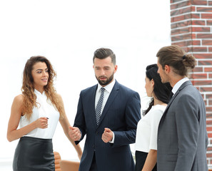 smiling business team talking, standing in office