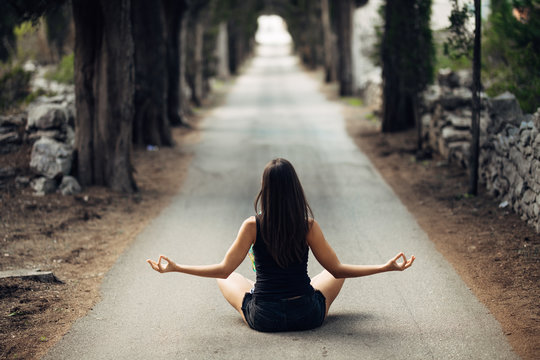 Carefree calm woman meditating in nature.Finding inner peace.Yoga practice.Spiritual healing lifestyle.Enjoying peace,anti-stress therapy,mindfulness meditation.Positive energy.Controling mind