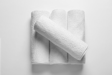 Rolled clean terry towels on white background, top view