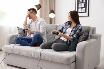 Young couple playing video games at home