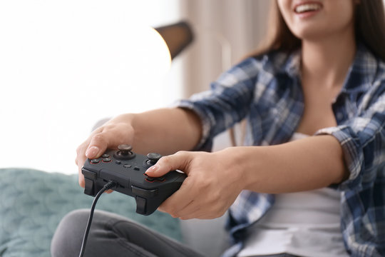 Young woman playing video games at home, closeup