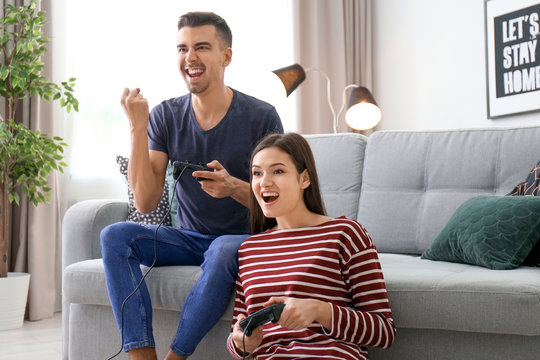 Young couple playing video games at home